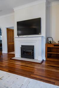 een woonkamer met een open haard en een flatscreen-tv bij Three Brothers Orchard in Oakbank