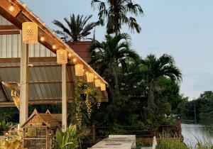 a building with lights on the side of it at Baan Suan Chay Nam Homestay Amphawa in Amphawa