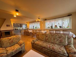 een woonkamer met een bank, een tafel en stoelen bij Vila Thomas in Sinaia