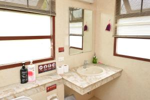 une salle de bain avec un lavabo et un miroir dans l'établissement Lost and Found Hideaway, à Bangkok 29 autres photos