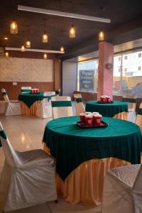a dining room with two tables with green and gold table cloth at Hotel Woodlark Zirakpur II A Peaceful Stay I Travelers Choice I Best for Family and Group in Chandīgarh