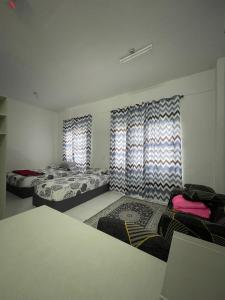 een slaapkamer met 2 bedden en een raam met gordijnen bij IFS Soho 3 in Kampong Bota Road
