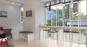 a living room with a bar with a couch and windows at Soontree House Hotel in Udon Thani