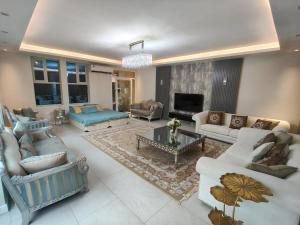 een grote woonkamer met banken en een open haard bij Luxury Villa Mansion Ajman in Ajman 