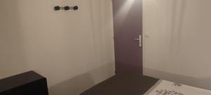 een kleine kamer met een deur en een bed bij Gîte L'hôtellerie in Trévron