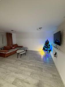 een woonkamer met een kerstboom in het midden bij Lad Petite Maison in Craiova