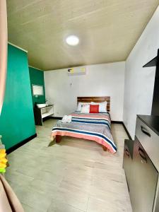 ein Schlafzimmer mit einem Bett in der Mitte eines Zimmers in der Unterkunft En-suite Paraiso #1 in Parrita
