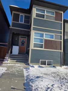 a house with a front door in the snow at YYC Cozy Suites in Calgary