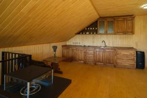 an attic kitchen with wooden cabinets and a sink at Шепіт Карпат in Yasinya