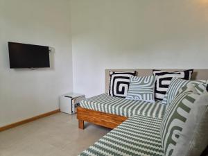 a living room with a couch and a flat screen tv at Villa detente 1 in Saint Gabriel