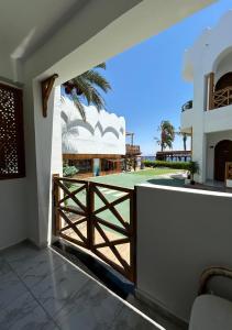une porte en bois donnant sur un balcon avec vue sur l'océan dans l'établissement Penguin Village Dahab, à Dahab