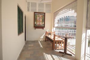 ein Zimmer mit einem Tisch und einem Fenster mit einer Bank in der Unterkunft Chandra Bagh in Māvli