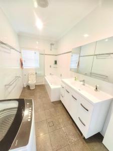 une salle de bain avec deux lavabos et une baignoire et des toilettes dans l'établissement Christian's Minde, Jervis Bay, à Sussex Inlet 72 autres photos
