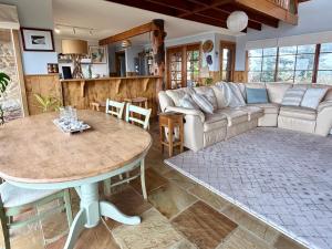 ein Wohnzimmer mit Sofa und Tisch in der Unterkunft Waterfront - Bluff Beach House, Park Beach in Dodges Ferry