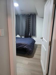 a bedroom with a bed in a small room at YYC Cozy Suites in Calgary