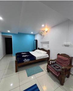 a bedroom with a bed and a chair at Costa Rica in Kumta