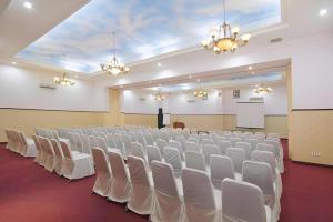 een grote kamer met witte stoelen en een podium bij Nalendra Hotel in Bandung +190 foto's