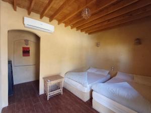 a bedroom with two beds and a night stand at Tunis Tone Ecolodge & Campsite in Fayoum Center