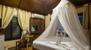 ein Schlafzimmer mit einem weißen Bett mit Himmelbett in der Unterkunft De Bua Valley in Ban Kom + 198 Fotos