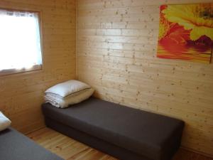 a room with a bed with a pillow and a window at Domki drewniane alpejskie in Świętne