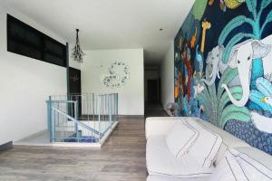 - un salon avec un canapé blanc devant une fresque dans l'établissement Villa Moreeda, à Thung Faek 223 autres photos