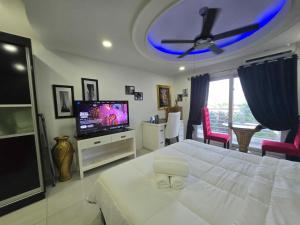 una camera con letto bianco e TV a schermo piatto di Studio at Kandi Palace near Walking street a Angeles