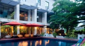 een huis met een zwembad voor een gebouw bij Klim Hotel in Buriram