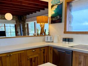 eine Küche mit Holzschränken und einer Arbeitsplatte in der Unterkunft Waterfront - Bluff Beach House, Park Beach in Dodges Ferry + 21 Fotos