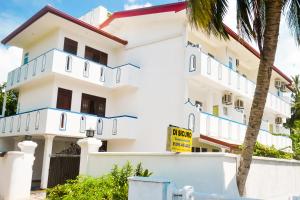 un bâtiment blanc avec un panneau devant lui dans l'établissement Di Sicuro Tourist Inn, à Hikkaduwa