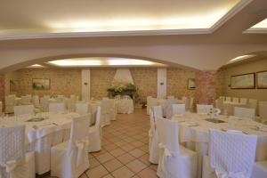 un salón de banquetes con mesas y sillas blancas en Hotel Pineta Ristorante country house in Fabriano, en Campodonico