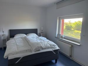 a bed in a bedroom with a window at Pure nature - Dein Landhaus in Wardow
