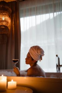 een vrouw in een bad met een glas wijn bij Hotel Rosenhof Murau in Murau