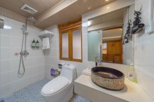 a bathroom with a sink and a toilet and a mirror at Travel & Rest Inn in Lijiang +42 photos