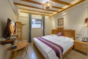 a bedroom with a large bed and a television at Travel & Rest Inn in Lijiang