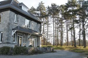 a stone house with trees in the background at Aux étangs fleuris in Rochefort