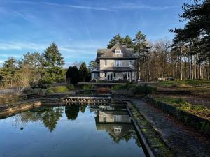 an old house sitting next to a river at Aux étangs fleuris in Rochefort