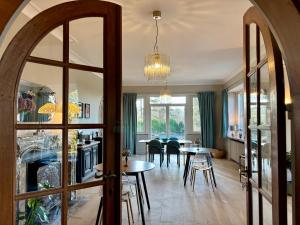a dining room with tables and chairs and a fireplace at Aux étangs fleuris in Rochefort