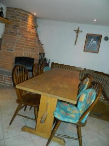 a dining room with a wooden table and a cross on the wall at Vacation Home Katarina in Čapljina