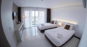 een hotelkamer met twee bedden en een televisie bij Chaisaeng Villa in Sing Buri