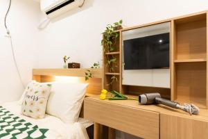 a bedroom with a tv and a bed with a pillow at 루미에르h호텔 in Seoul +32 photos