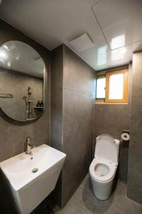 a bathroom with a sink and a toilet and a mirror at 루미에르h호텔 in Seoul