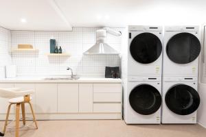 two washing machines in a kitchen with a sink at 루미에르h호텔 in Seoul
