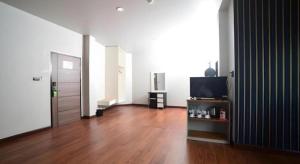 een woonkamer met een televisie en een houten vloer bij CHANTHABURI CENTER in Chanthaburi