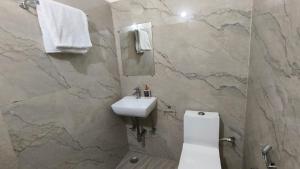 a bathroom with a sink and a toilet and a mirror at Prem villas homestay in Tājganj