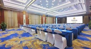 une grande salle de banquet avec des tables bleues et des chaises blanches dans l'établissement Horizon Hotel, à Kunming