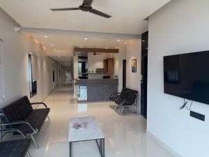 a living room with a couch and a tv on a wall at Palukuri's Grand in Vizianagram City +23 photos