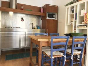una cucina con tavolo in legno e sedie blu di CasaBlanca Apartment a Roma