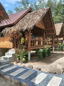 a house with a thatched roof at Bansuan Lanta Maikaew in Ko Lanta
