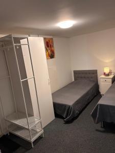 a small room with a bed and a book shelf at Mini Hus in Märsta