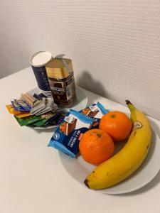 a plate with a banana and oranges on a table at Mini Hus in Märsta